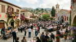 Easter celebrations in a Cypriot village square with people gathering around tables and festive decorations